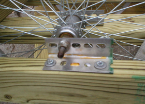Вид на крепление оси колеса через отверстия в уголке